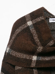 Macro detail of brown and white checkered knit fabric with a soft wool texture