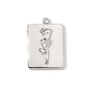 Detailed view of silver rectangular pendant with embossed rose pattern and ring bail