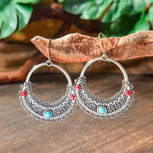 Detailed view of Bohemian drop earrings with blue and red beads on antique silver finish
