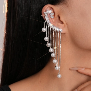 Détail d'une boucle d'oreille fleur élégante avec pampilles en zircon et perles nacrées