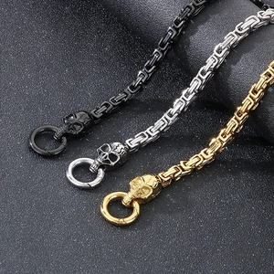 Close-up of hip-hop skull connectors on Byzantine steel chains in gold, silver, and black