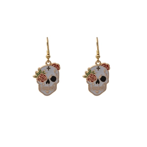 Detailed macro view of sugar skull earrings with red roses and green leaves design