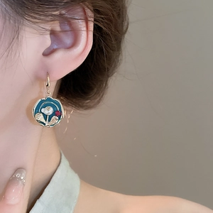 Vintage gold plated earrings with blue enamel flowers and pearls worn by a model