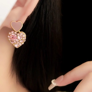 Macro detail of a double layered pink heart earring with sparkling rhinestones on a model
