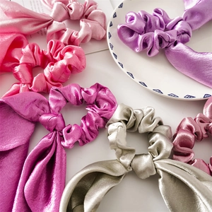 Detailed macro view of satin scrunchies with streamers on a white decorative plate