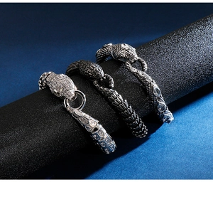 Detailed trio of snake head bracelets in silver and black finishes on display