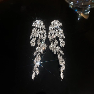 Macro shot of silver feather tassel earrings with sparkling marquise cut crystals