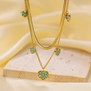 Close-up of double layer gold-plated steel necklace with heart-shaped evil eye pendant