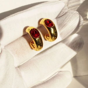 Boucles d'oreilles créoles C dorées vintage avec zircons rubis ovales sous le soleil