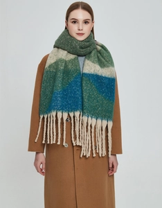 Detail of colorful gradient knit scarf with geometric color blocks and long tassels