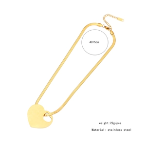 Detailed close-up of golden stainless steel heart pendant and flat snake chain necklace