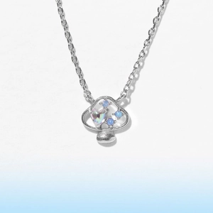 Primo piano di una collana con ciondolo a fungo e uno zircone colorato a forma di cuore
