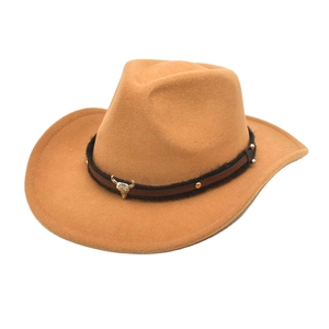Detail of camel wool cowboy hat featuring a leather band and metal bull head skull accessory