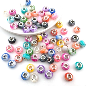 Detailed macro shot of colorful large hole beads with marble textures and metal centers