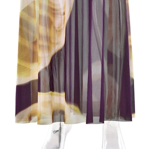 Dettaglio gonna in mesh con stampa astratta gialla e viola e bordo inferiore plissettato