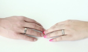 Close-up of titanium couple rings with a simple male band and a paved female ring