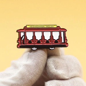 Red vintage trolley enamel pin featuring Neighborhood Trolley text on yellow background