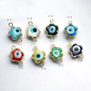 Detail of eight flower-shaped evil eye enamel pendants in assorted vibrant colors