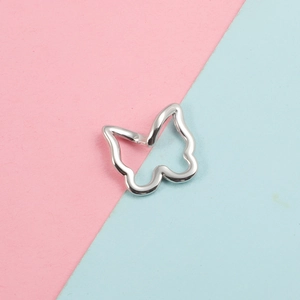 Détail d'un pendentif papillon en argent sur un fond bicolore rose et bleu