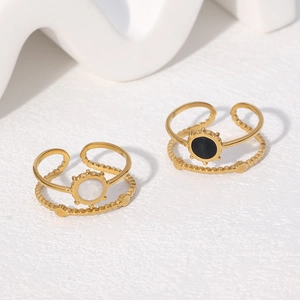 Detail view of double-layered adjustable gold rings with black and white circular inlays