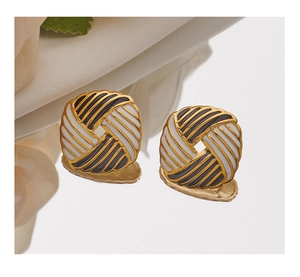 Macro detail of square striped enamel earrings with gold plating on a reflective surface