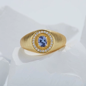 Close-up of golden S925 silver ring with blue tanzanite gemstone on white stone