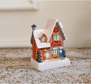Macro shot of miniature candy shop with glowing interior and snowy Christmas festive details