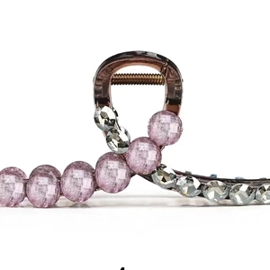 Detailed macro view of small hair claw clip with purple crackle beads and crystals