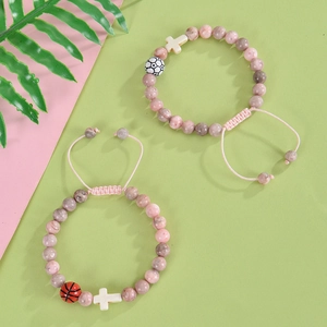 Pink and brown spotted beaded bracelet set with white cross and soccer ball charms