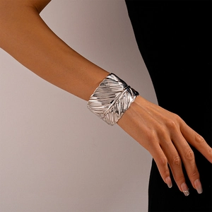Detailed macro view of the silver leaf texture and crinkled pattern on the metal cuff bracelet