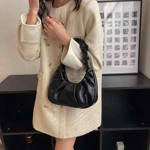French style ruched underarm bag in black leather shown held by a fashion model