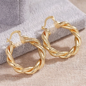 Detailansicht goldener Creolen mit glatter und matter strukturierter Oberfläche