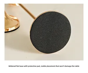 Close-up of golden candle holder wide base with black anti-slip protective pad