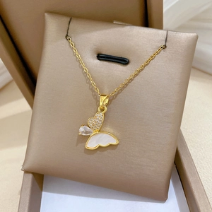Close-up of golden butterfly pendant with sparkling zircons and white shell inlay
