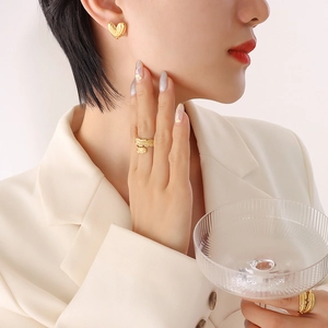 Golden heart earrings and feather open rings set worn by a model in elegant style