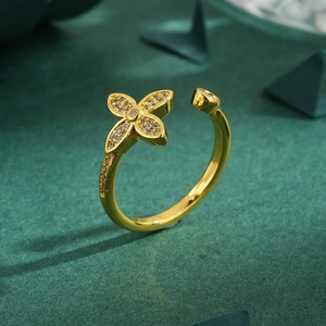 Elegant gold clover open ring with sparkling cubic zirconia on a luxury dark background