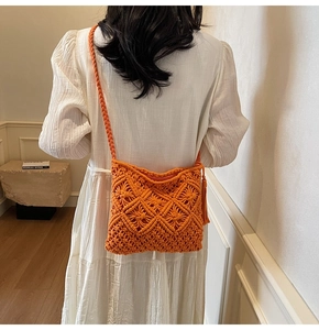 Détail du sac bandoulière orange en macramé avec texture tissée et longues franges latérales