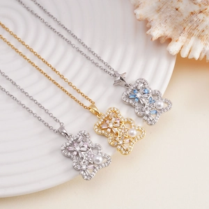 Elegant bear pendant necklaces with shimmering zircons and pearls on a white plate