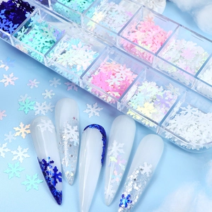 Detailed view of 12-grid Christmas snowflake nail sequins in a transparent storage box