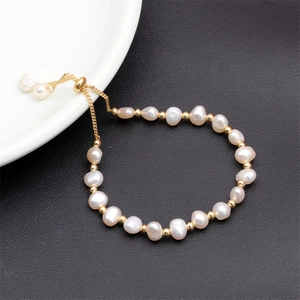 Detail of baroque freshwater pearl bracelet with gold beads and adjustable clasp chain
