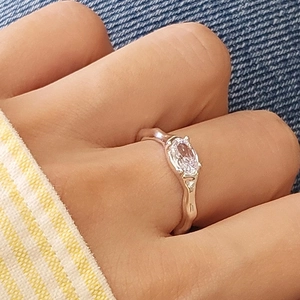 Irregular silver fluid texture ring with oval zircon gemstone shown on a model hand