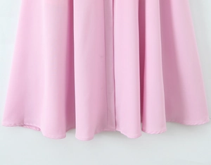 Dettaglio dell'orlo del vestito rosa che mostra il tessuto morbido e le cuciture pulite