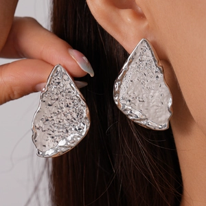 Minimalist silver irregular geometric earrings with molten metal texture worn by model