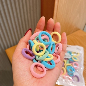 Close-up of colorful macaron hair ties held in hand showing elastic fabric texture