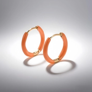 Detailed close-up of golden titanium hoop earrings with vibrant orange enamel inlay