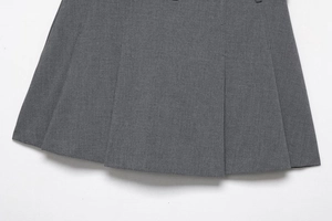 Detail shot of high-quality dark grey pleated skirt showing thick twill fabric texture