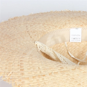 Detail view of the breathable fabric sweatband and lace trim inside the raffia sun hat