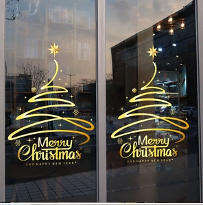 Detalle de pegatinas doradas de árbol de Navidad y texto Merry Christmas en puertas vidrio