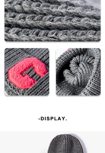 Detail of chunky knit dark grey beanie featuring a red embroidered letter C patch