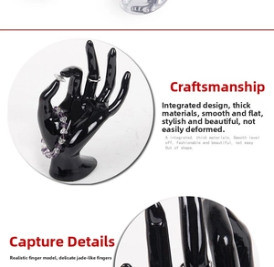 Detail of glossy black hand jewelry display stand showing rings and bracelets with resin finish